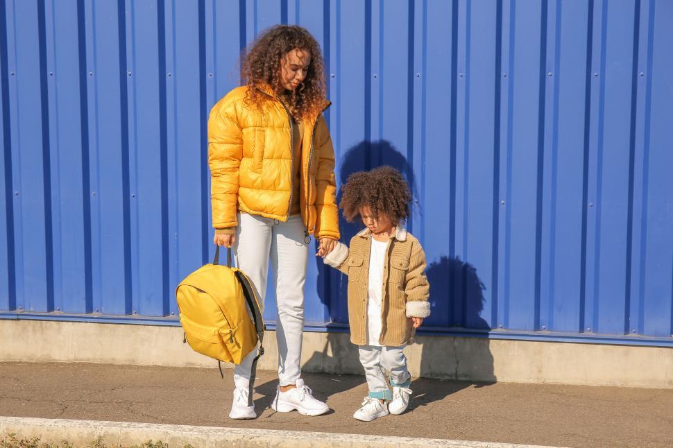 Free Image of Mother and child walking against blue background 