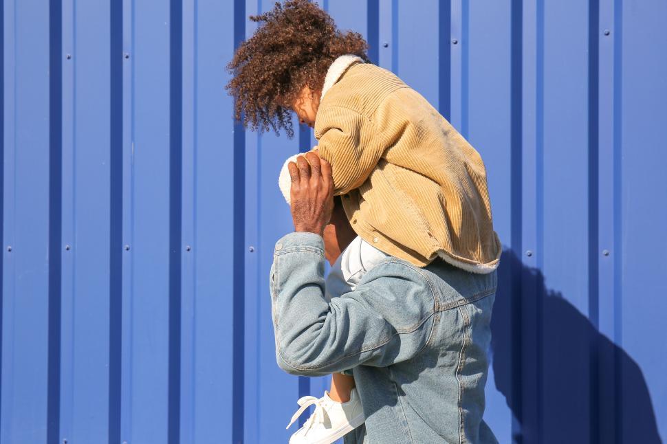 Free Image of Young adult with ice cream against blue wall 