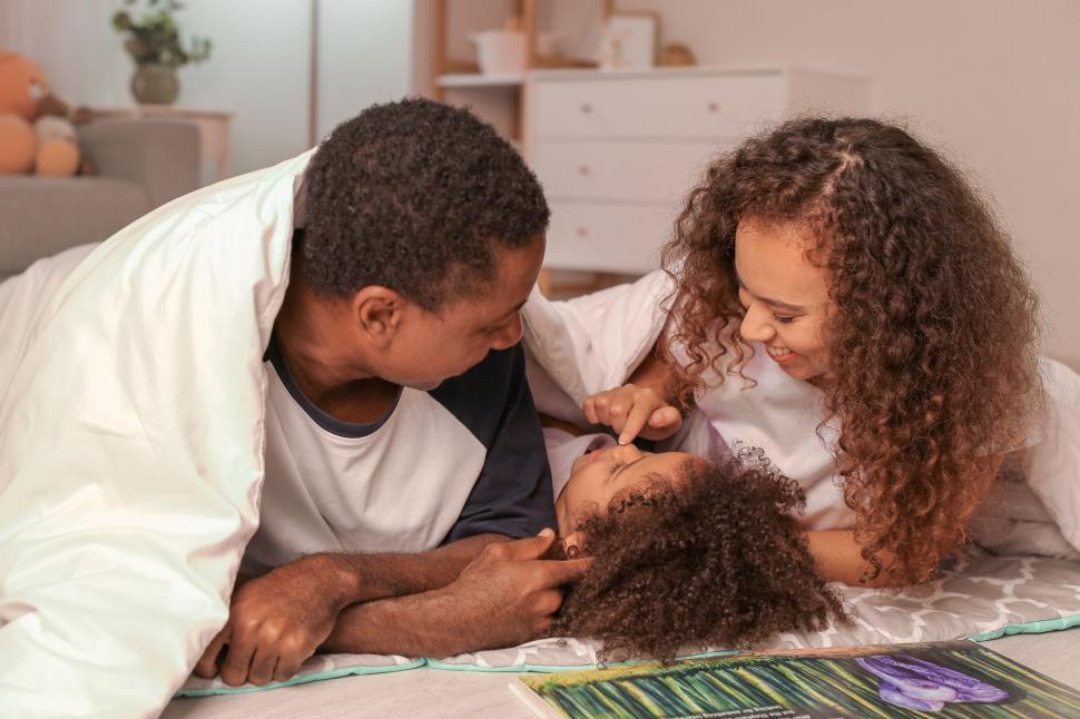 Free Image of Family comforting sick child in bed 