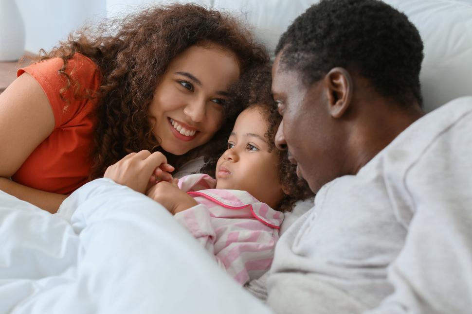 Free Image of Close-knit family sharing a moment in bed 