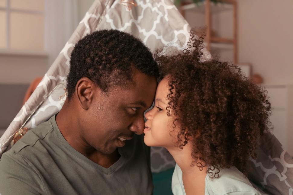 Free Image of Intimate father-daughter bonding moment under blanket 