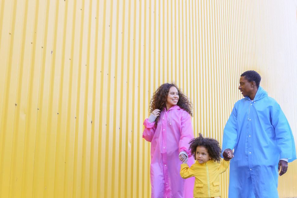 Free Image of Family walk against yellow wall 