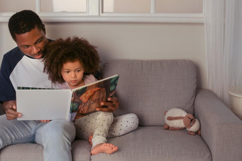 Free Image of Father and daughter reading on sofa 