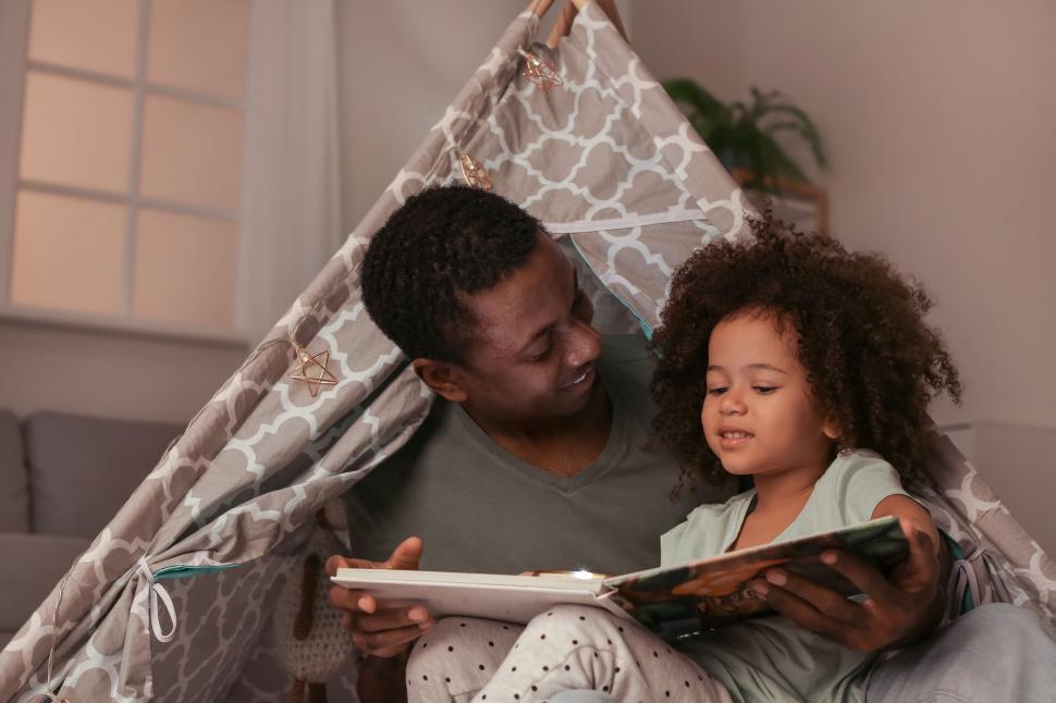 Free Image of Family reading under homemade tent 
