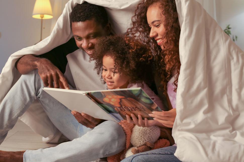 Free Image of Reading a book together under blankets 