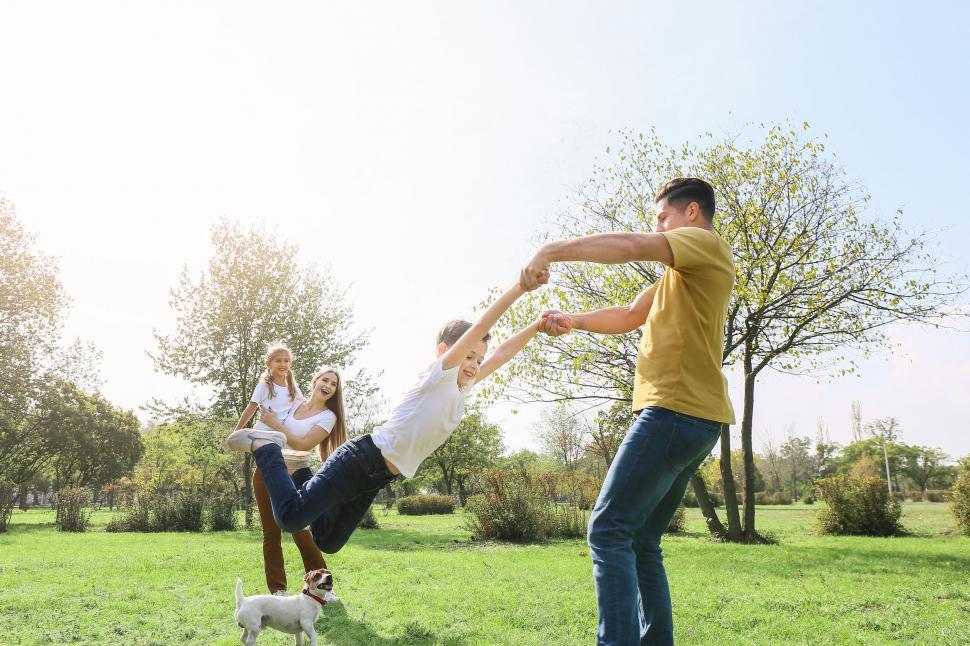 Free Image of Family playing swinging child outdoors sunlight 