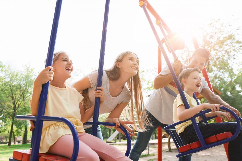 Free Image of Family playing together on a see-saw in park 