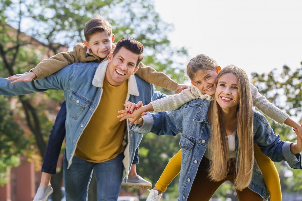 Free Image of Family giving piggyback rides and smiling 