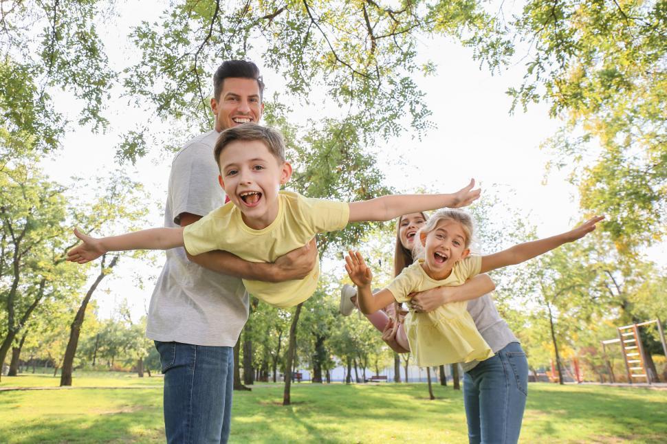 Free Image of Family playing airplane game in park 