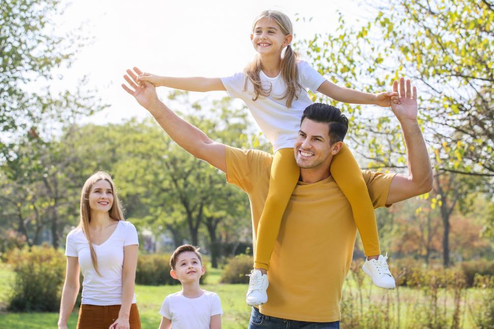 Free Image of Young girl on father s shoulders in park 