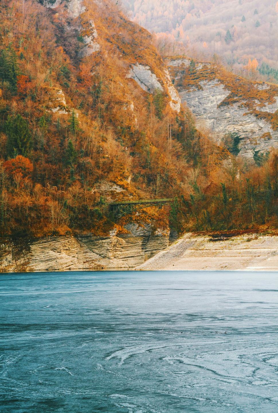 Free Image of Autumn colors reflecting on frozen lake 