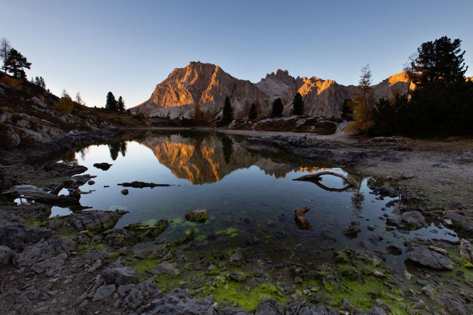 Free Image of Sunset casting golden light on a tranquil lake 