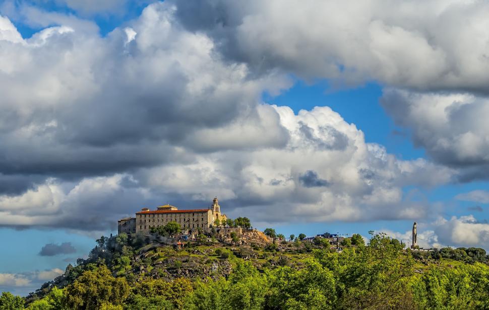 Free Image of Historic fortress on a hill under cloud sky 