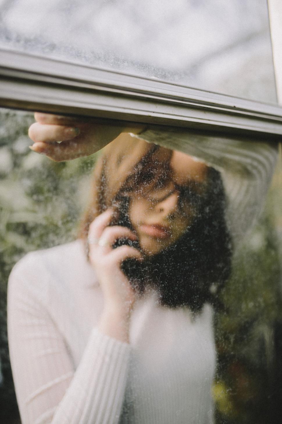 Free Image of Woman opening a window to look outside 