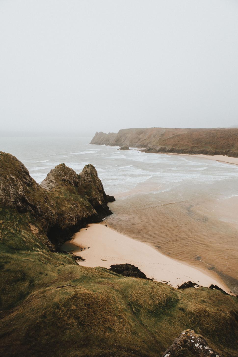 Free Image of Coastal beach view with rocky cliffs 