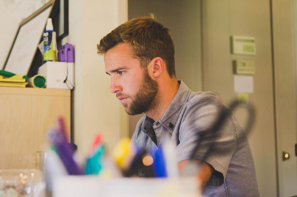 Free Image of Man working at a cluttered desk 