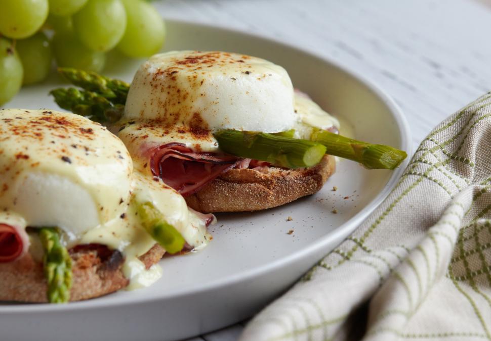 Free Image of Eggs Benedict on a white plate with asparagus 