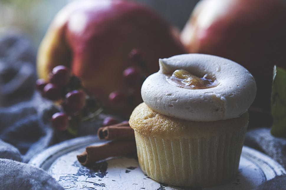 Free Image of Cupcake with creamy topping and apple background 