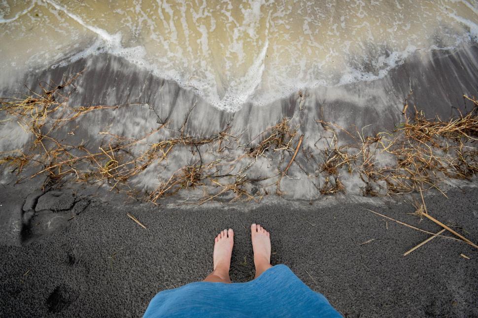 Free Image of Person standing on beach looking at waves 