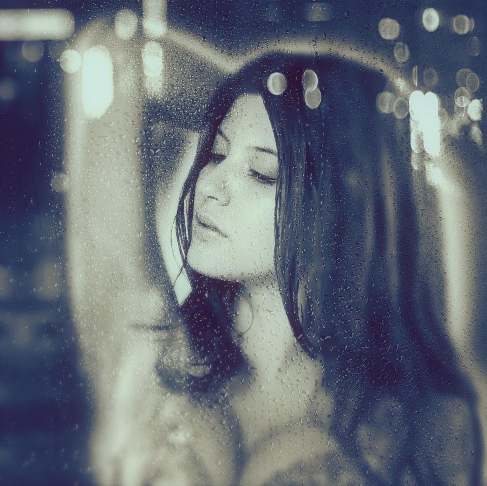 Free Image of Woman behind rainy window in monochrome 