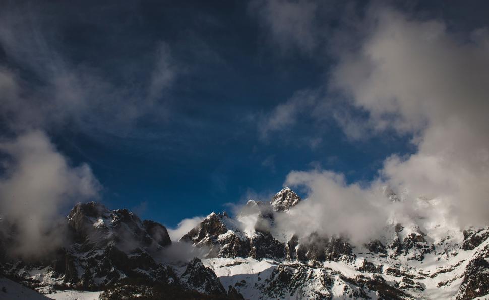 Free Image of Majestic snowy mountain peaks with clouds 