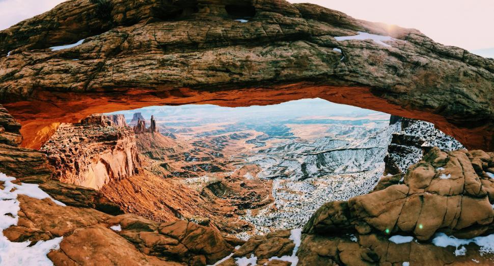 Free Image of Snowy arch overlooking a rugged canyon view 