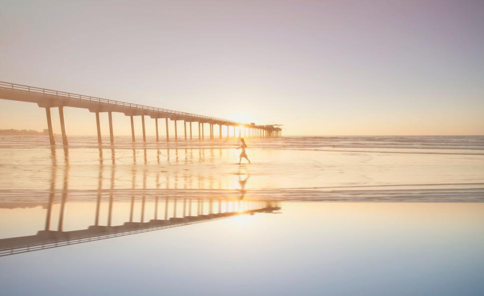 Free Image of Silhouette on a beach pier at sunset 