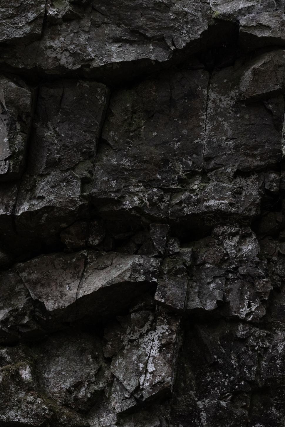 Free Image of Dark textured stone wall surface 