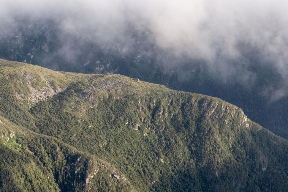Free Image of Misty mountain peaks with forested slopes 