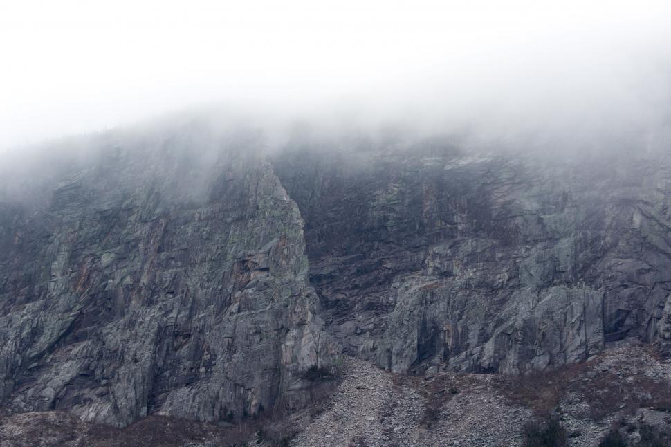 Free Image of Misty mountain rock face engulfed in fog 