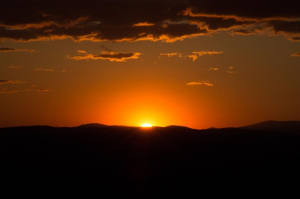 Free Image of Sunset casting golden glow over mountain range 