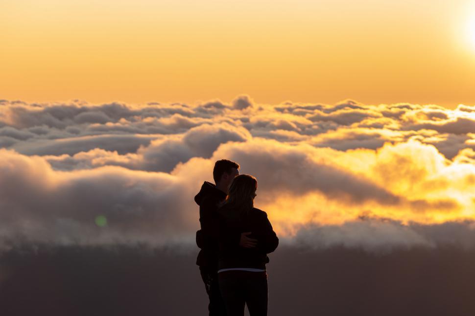 Free Image of Couple overlooking sea of clouds at sunset 