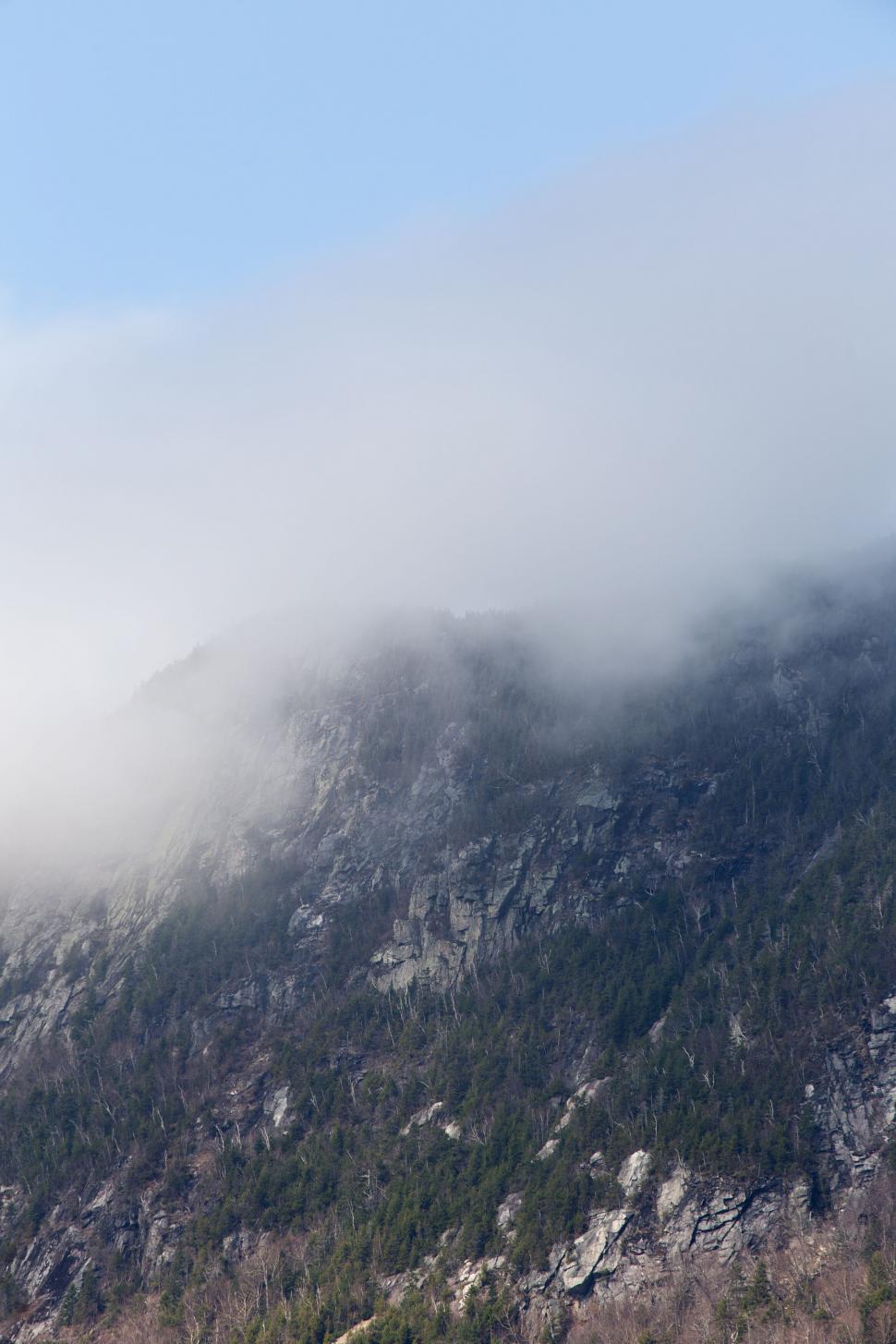 Free Image of Misty mountain peak emerging from clouds 