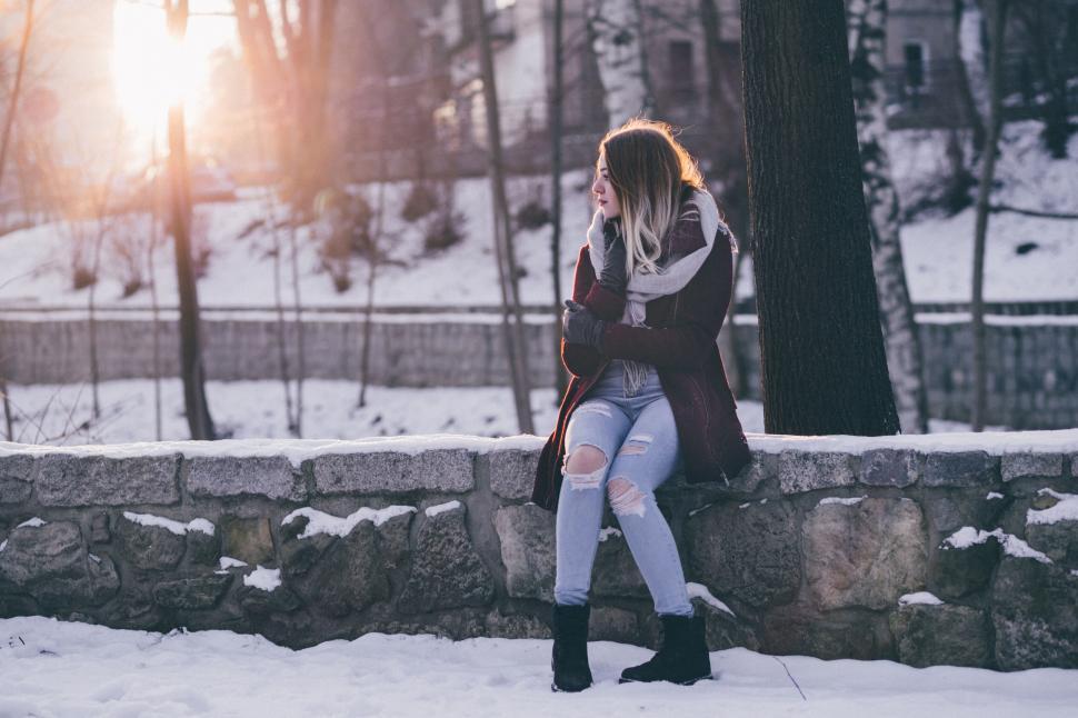 Free Image of Woman sitting alone on snowy bench 