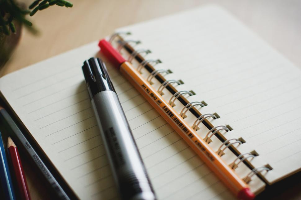 Free Image of Notebook and pens on wooden table 