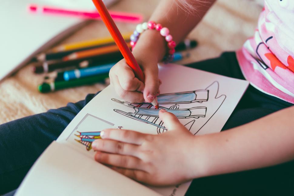 Free Image of Child coloring with pencils on paper 