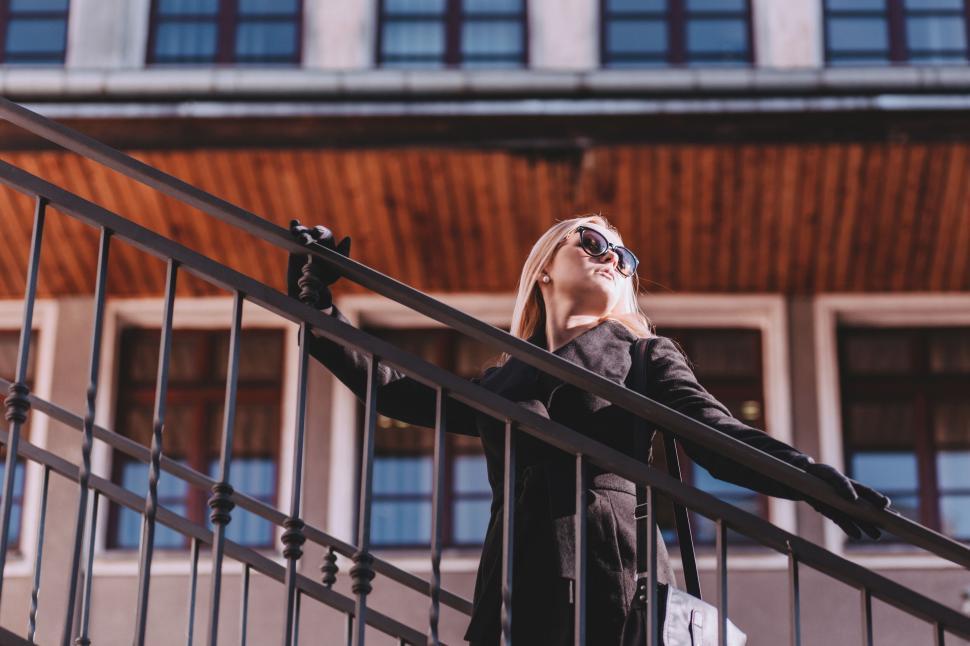 Free Image of Woman with bag head stands on steps 