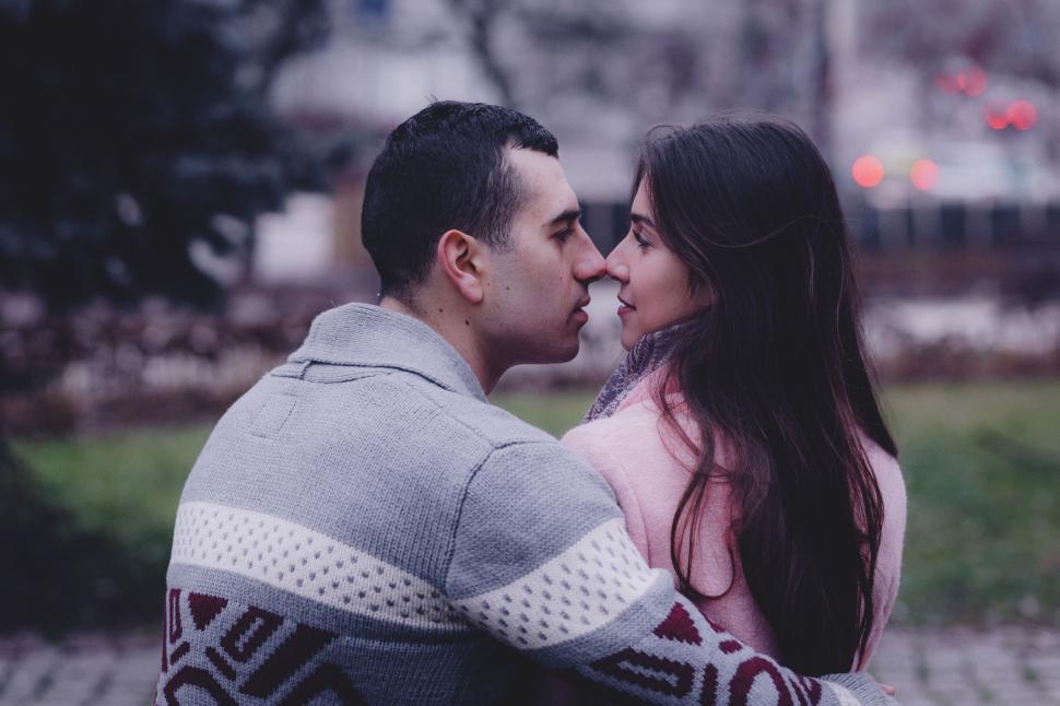 Free Image of Couple embracing and looking away in a park 