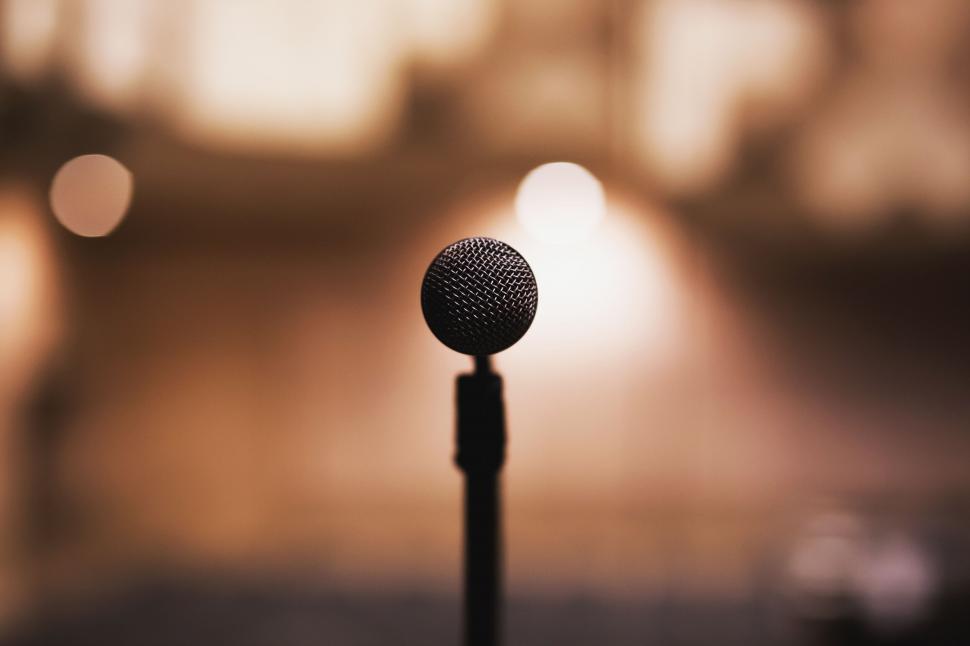 Free Image of Silhouetted microphone against a blurry sunset 