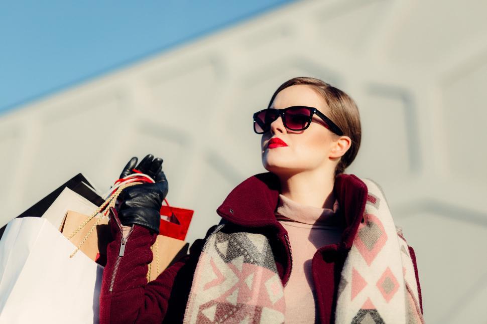 Free Image of Stylish shopper with bags enjoying sunshine 