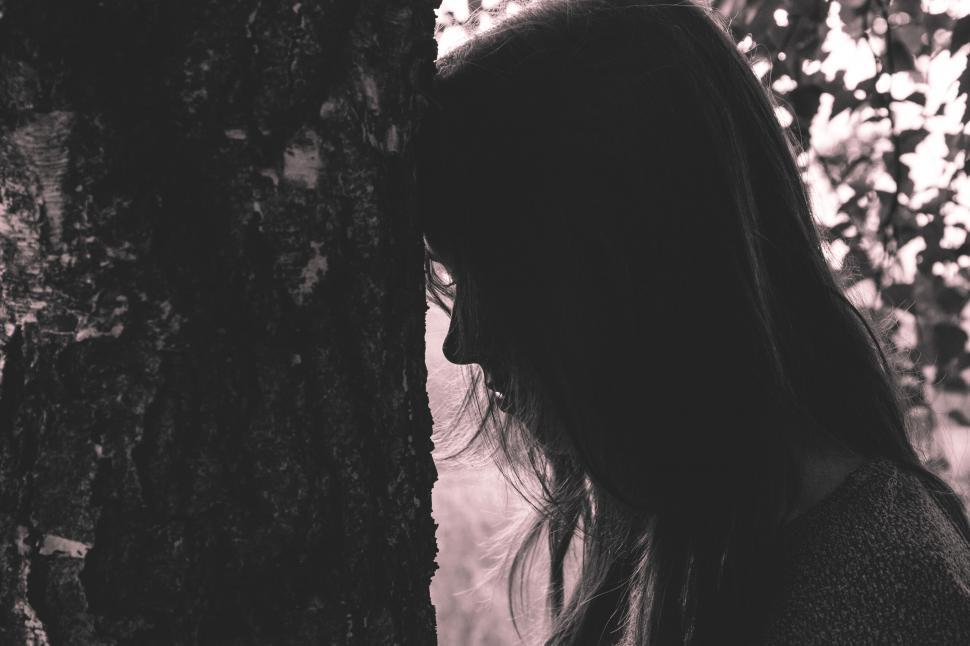 Free Image of Silhouette of a woman by a tree 