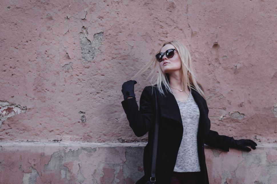 Free Image of Woman posing by rustic wall texture 