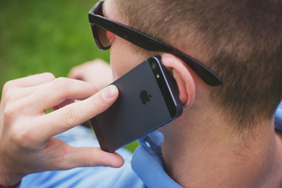 Free Image of Man speaking on iPhone with blurred background 