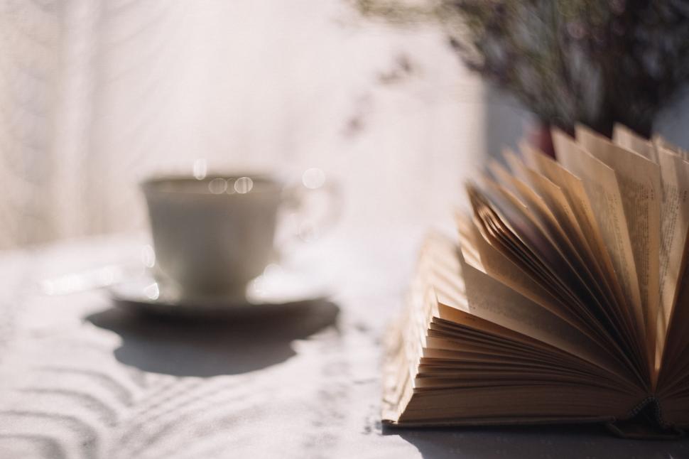 Free Image of Blurred book and tea cup on a sunny table 