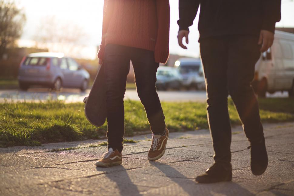 Free Image of Two people walking on the street at sunset 