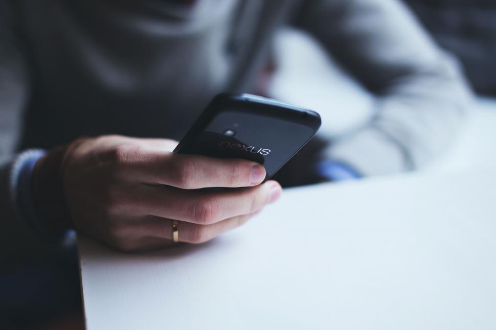 Free Image of Person holding a smartphone with a black case 