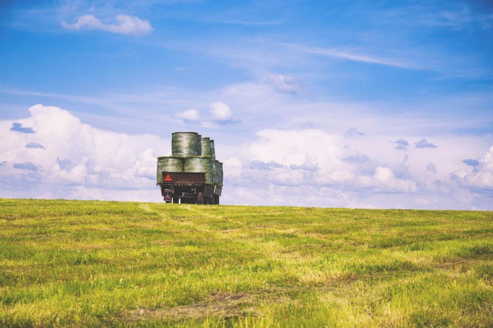 Free Image of Rural landscape with hay bales on trailer 