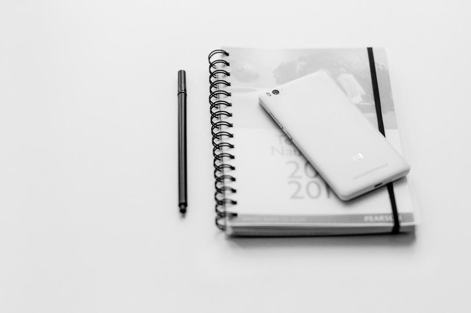 Free Image of Notebook with a pen and smartphone on desk 