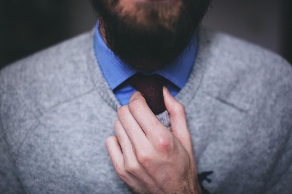 Free Image of Man adjusting his tie in close-up shot 