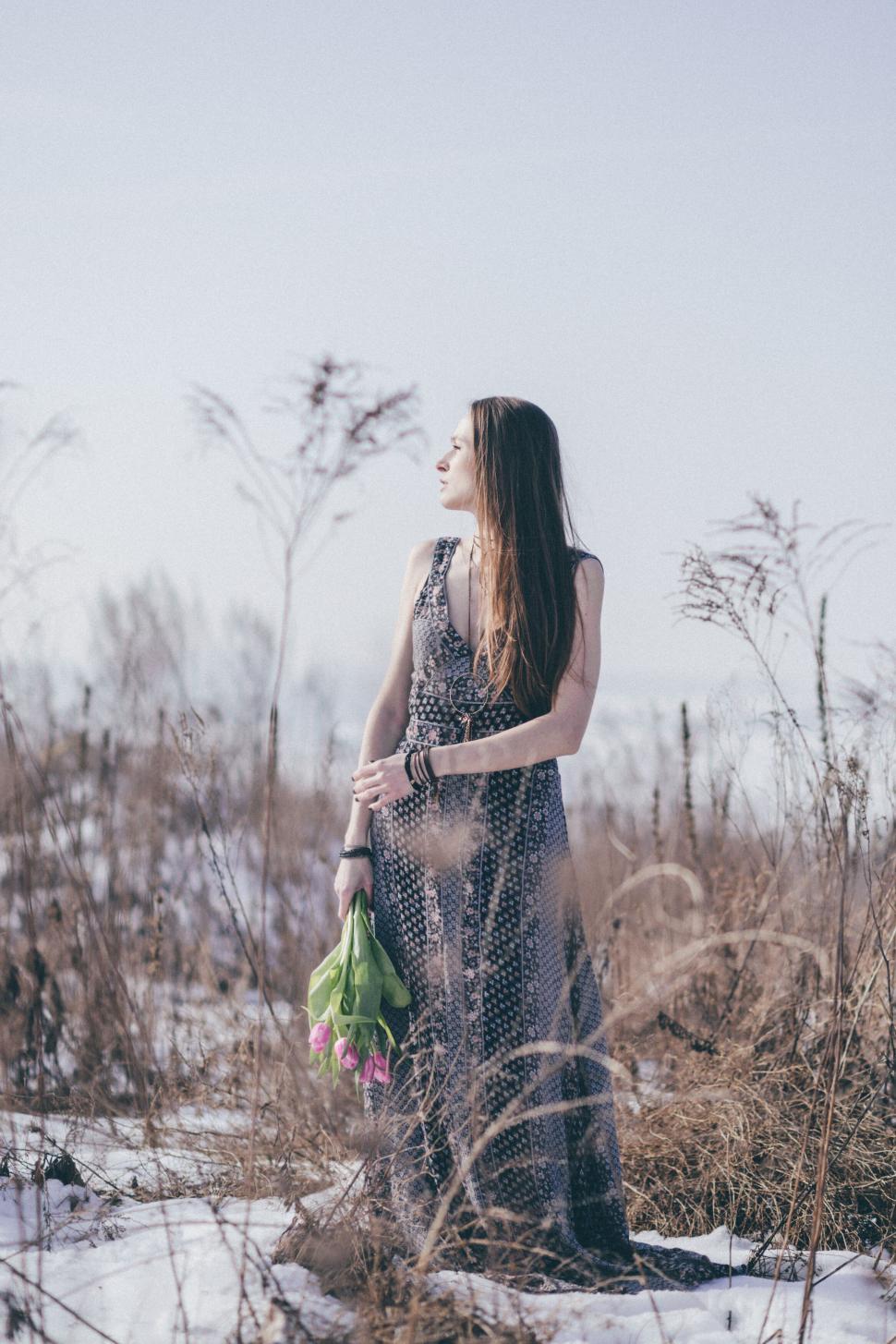 Free Image of Woman in dress standing in snowy field 